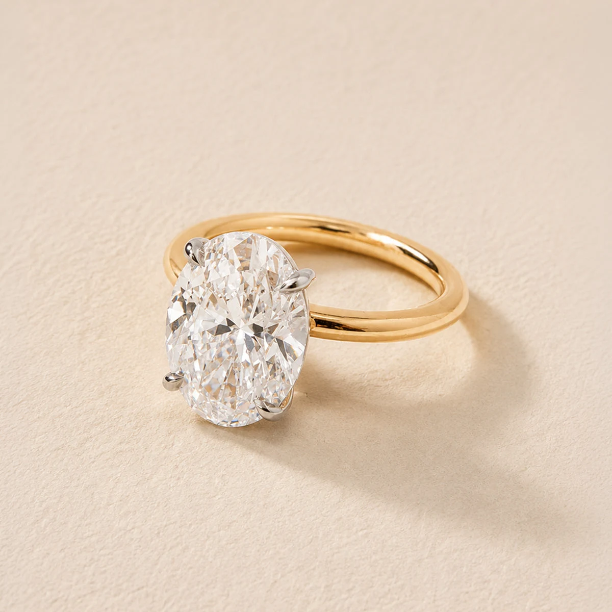 Close-up of an oval diamond solitaire ring on a textured surface