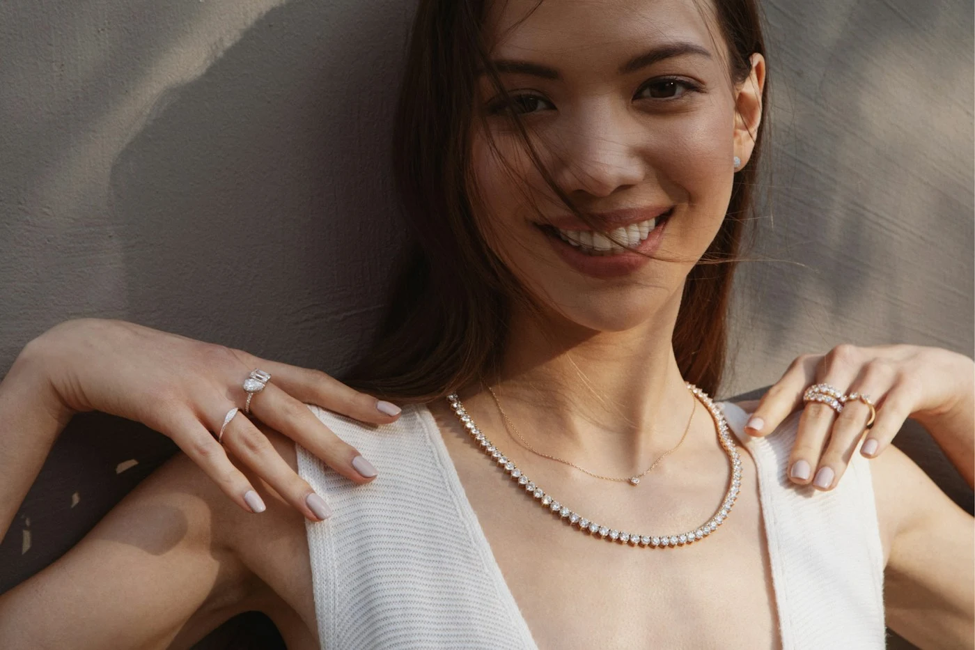 A woman wearing diamond necklaces, diamond rings and diamond studs