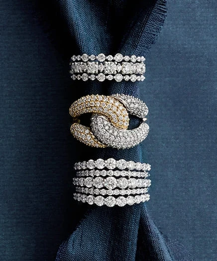 Groups of diamond-set bands arranged on dark blue textured fabric